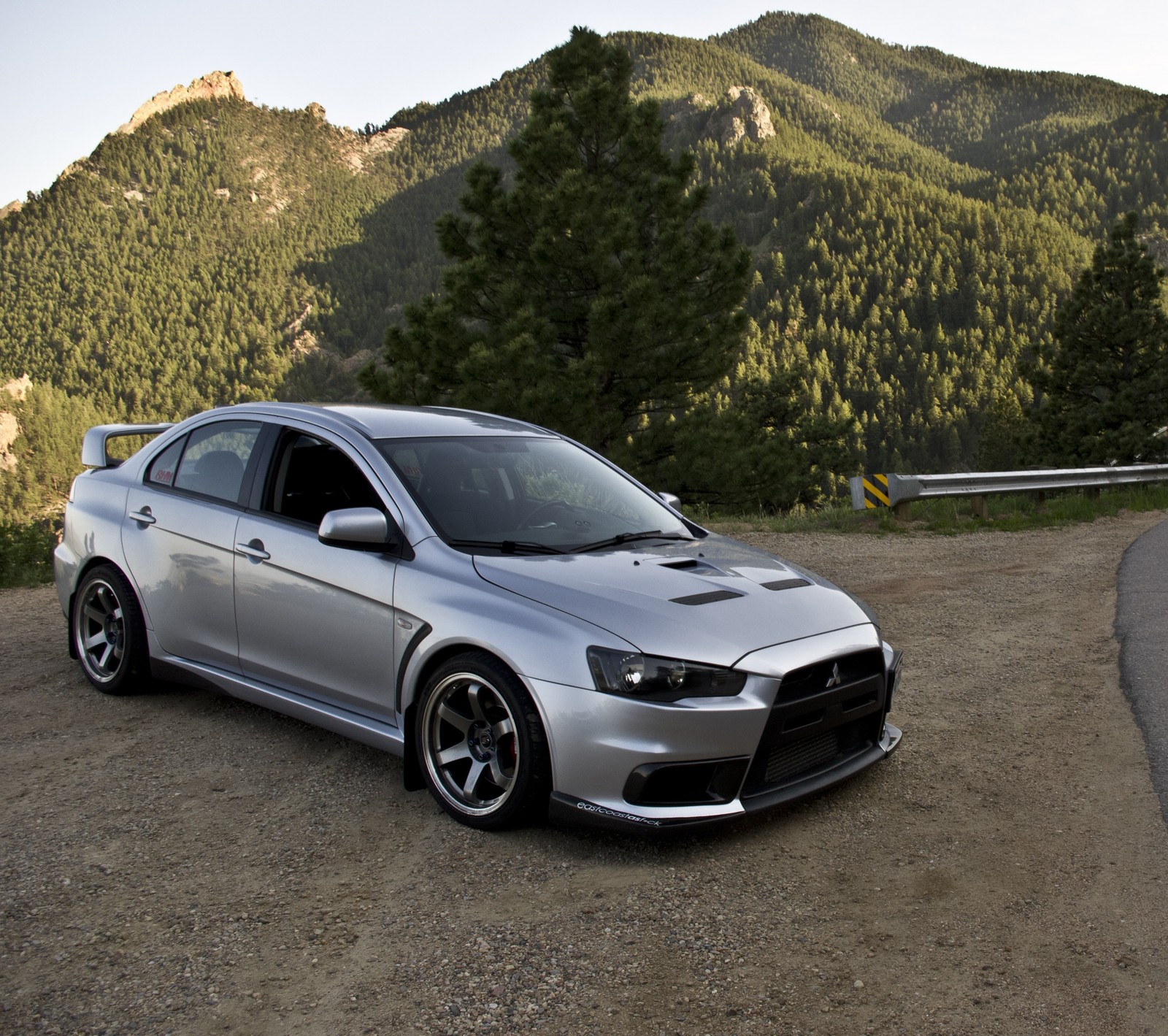 Arafed silver car parked on a dirt road near a mountain (ev, evo, lancer, mitsubishi, mitsubishi club moldova)