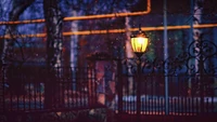 Farola iluminada que emite un cálido resplandor en la oscuridad de la tarde