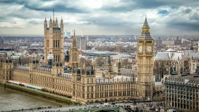 Vista do Big Ben e do Palácio de Westminster com vista para o rio Tâmisa em uma paisagem urbana movimentada.