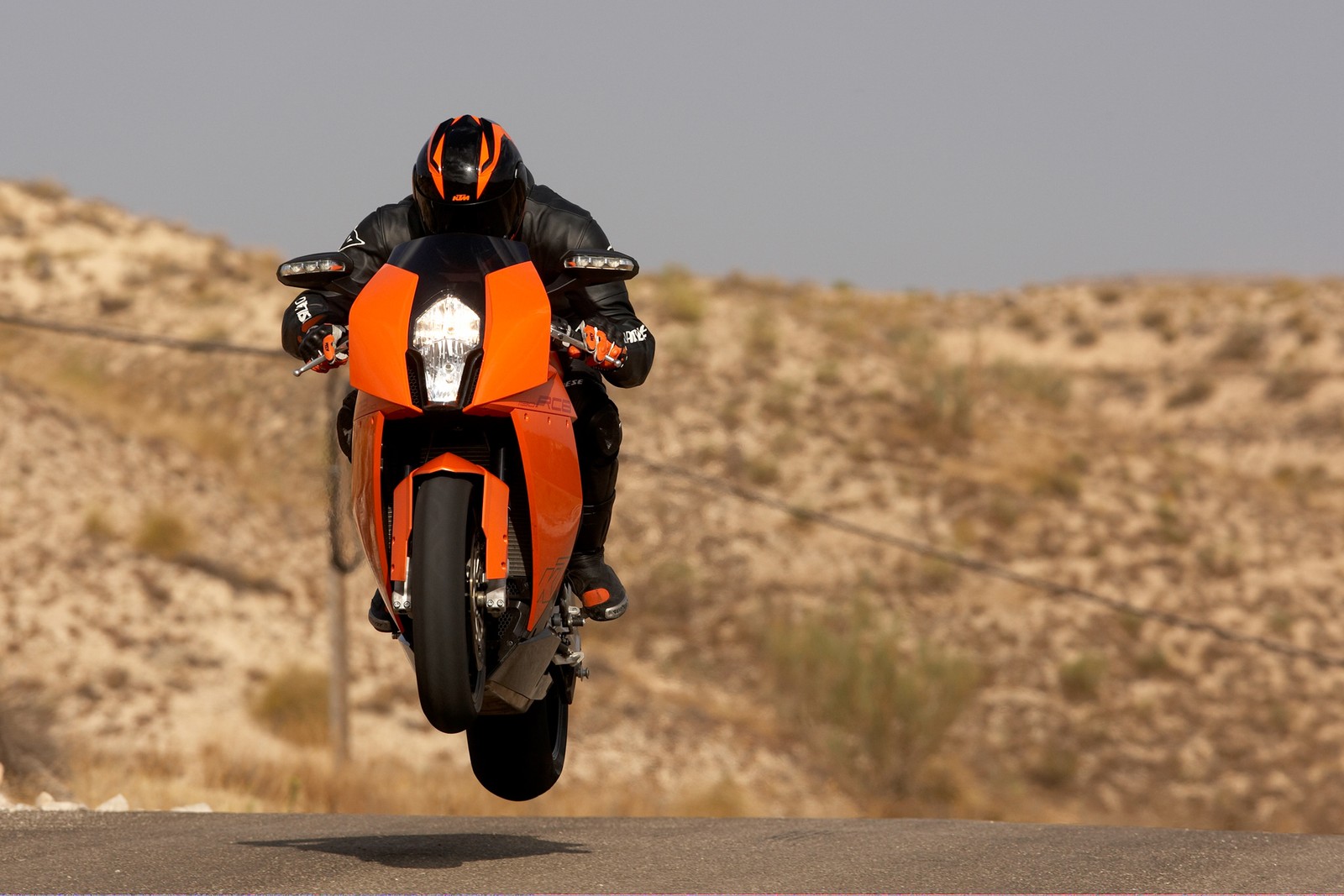 Hay un hombre montando una motocicleta en una carretera del desierto (ktm, motocicleta, motociclismo, especialista, carreras)