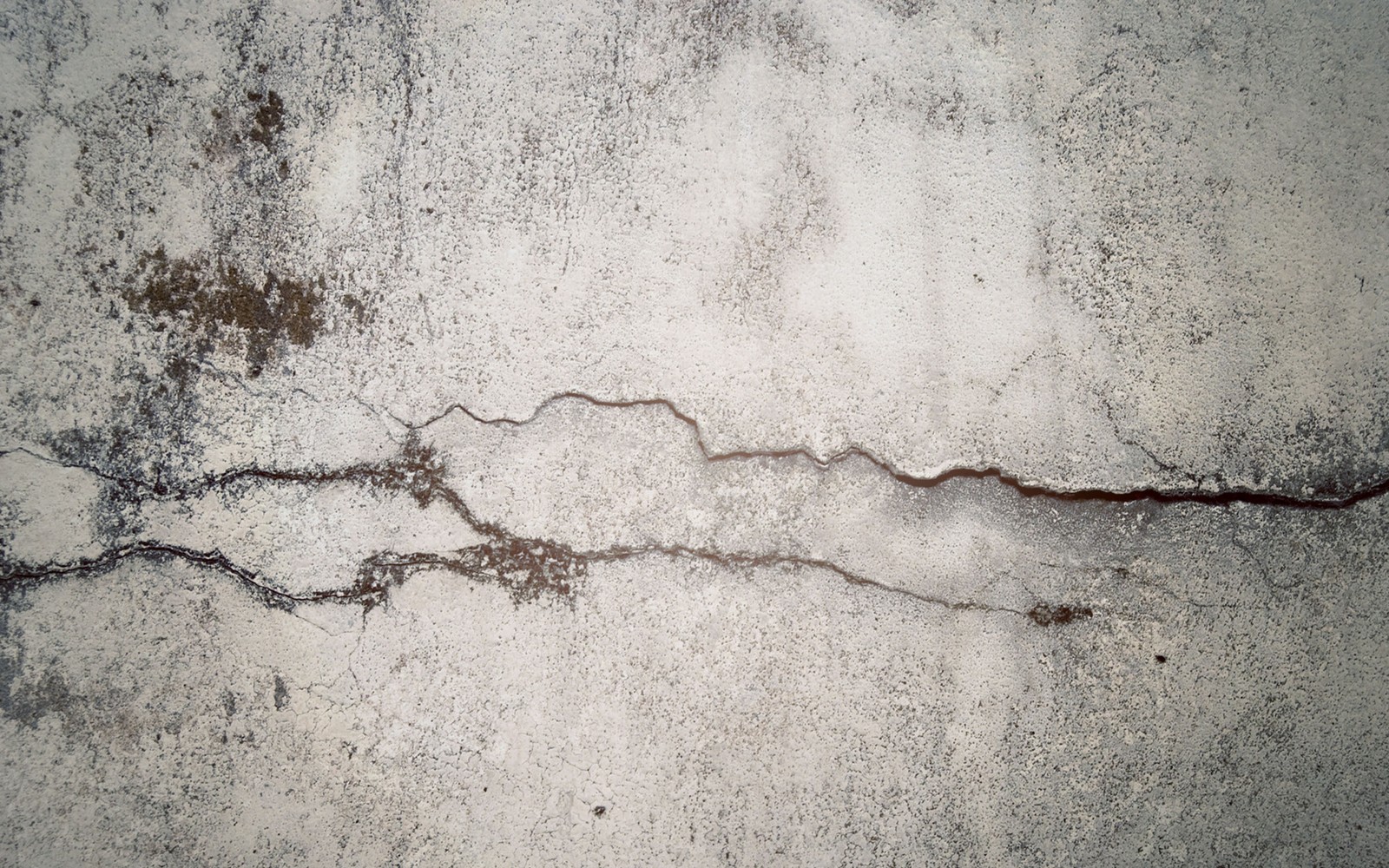 A close up of a wall with a crack in it (stone wall, texture, wall, cement, concrete)