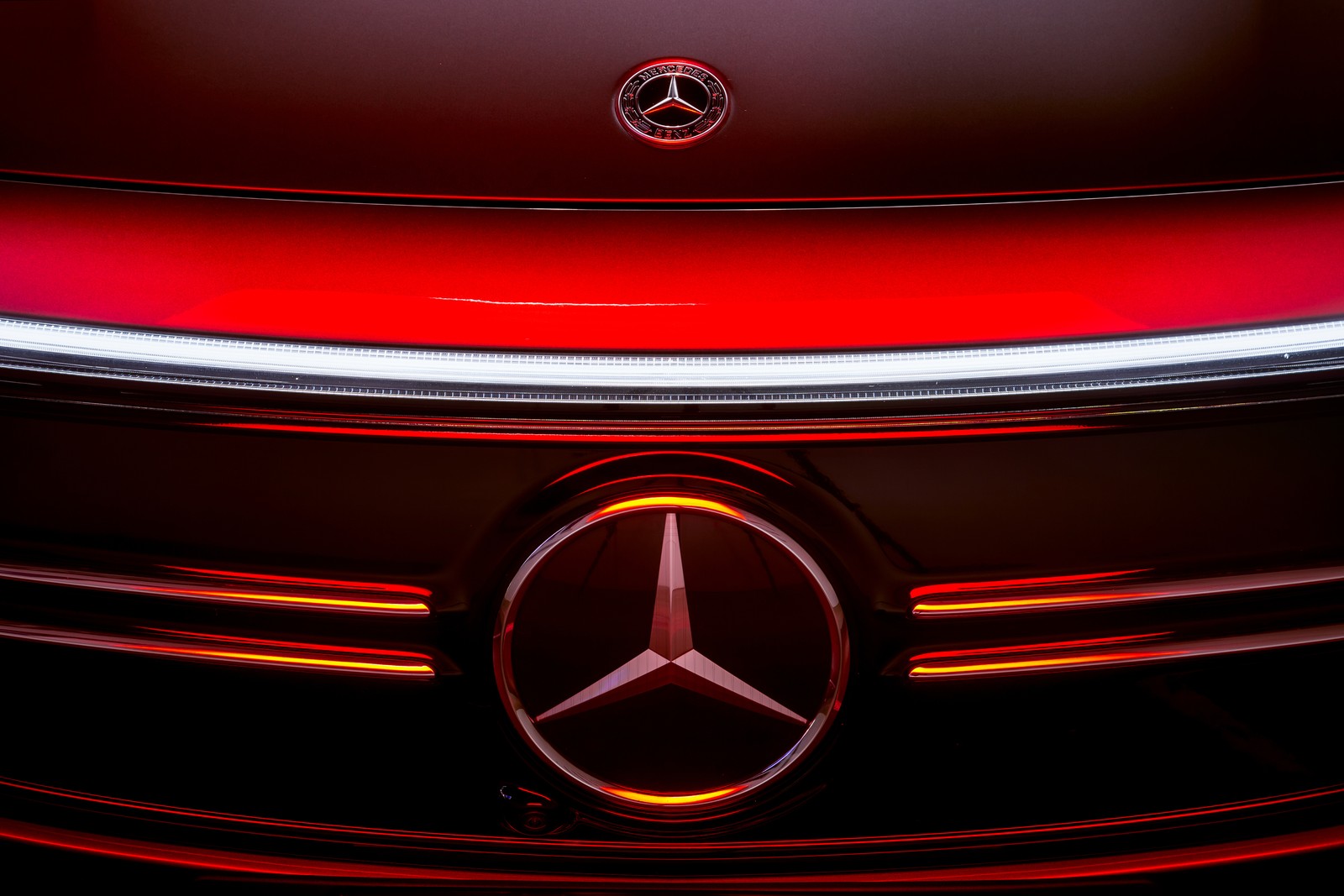 A close up of a mercedes logo on a red car (mercedes benz eqa 250 amg line, 2021, three pointed star, cars, 4k wallpaper)