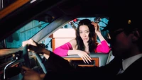 Tiffany Young em uma cena de carro estilosa, exalando carisma e elegância.