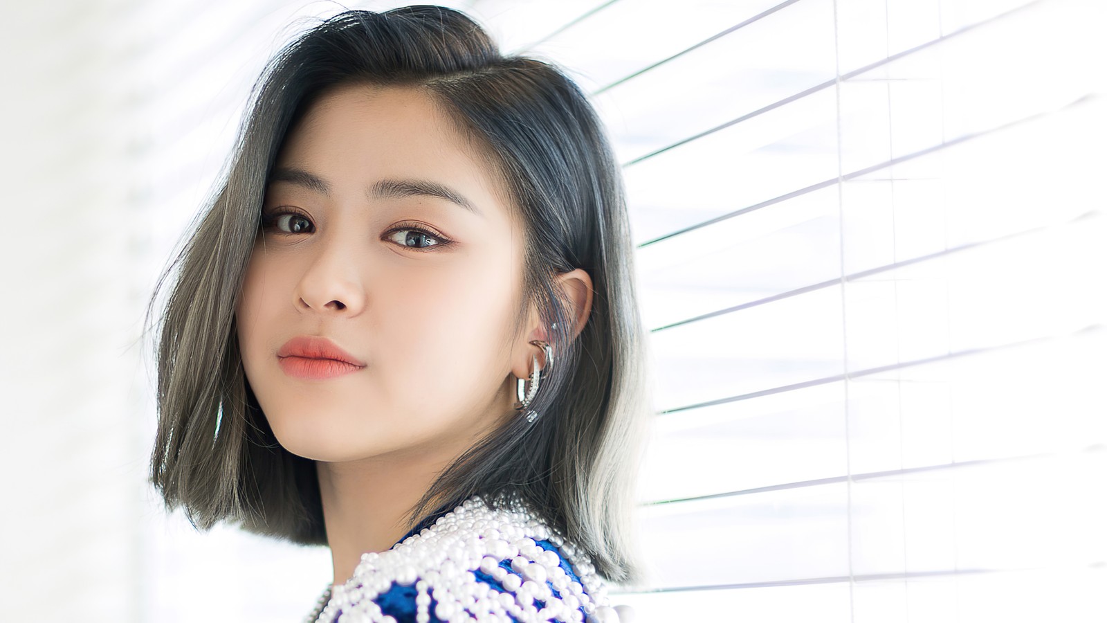 Une femme aux cheveux courts et portant des boucles d'oreilles se tenant devant une fenêtre (ryujin, 류진, shin ryu jin, 신류진, itzy)