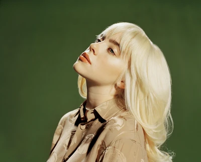 Billie Eilish in a stylish pose with blonde hair and a patterned shirt against a green background.