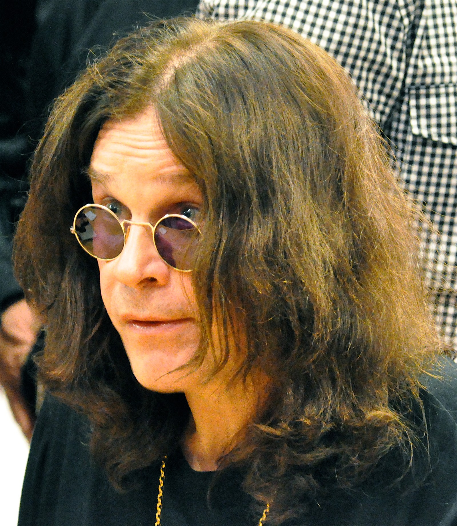 Mulher árabe com óculos e um colar sentada à mesa (ozzy osbourne, os osbournes, the osbournes, black sabbath, óculos)