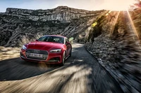 Audi A5 dynamique en mouvement sur une route de montagne pittoresque