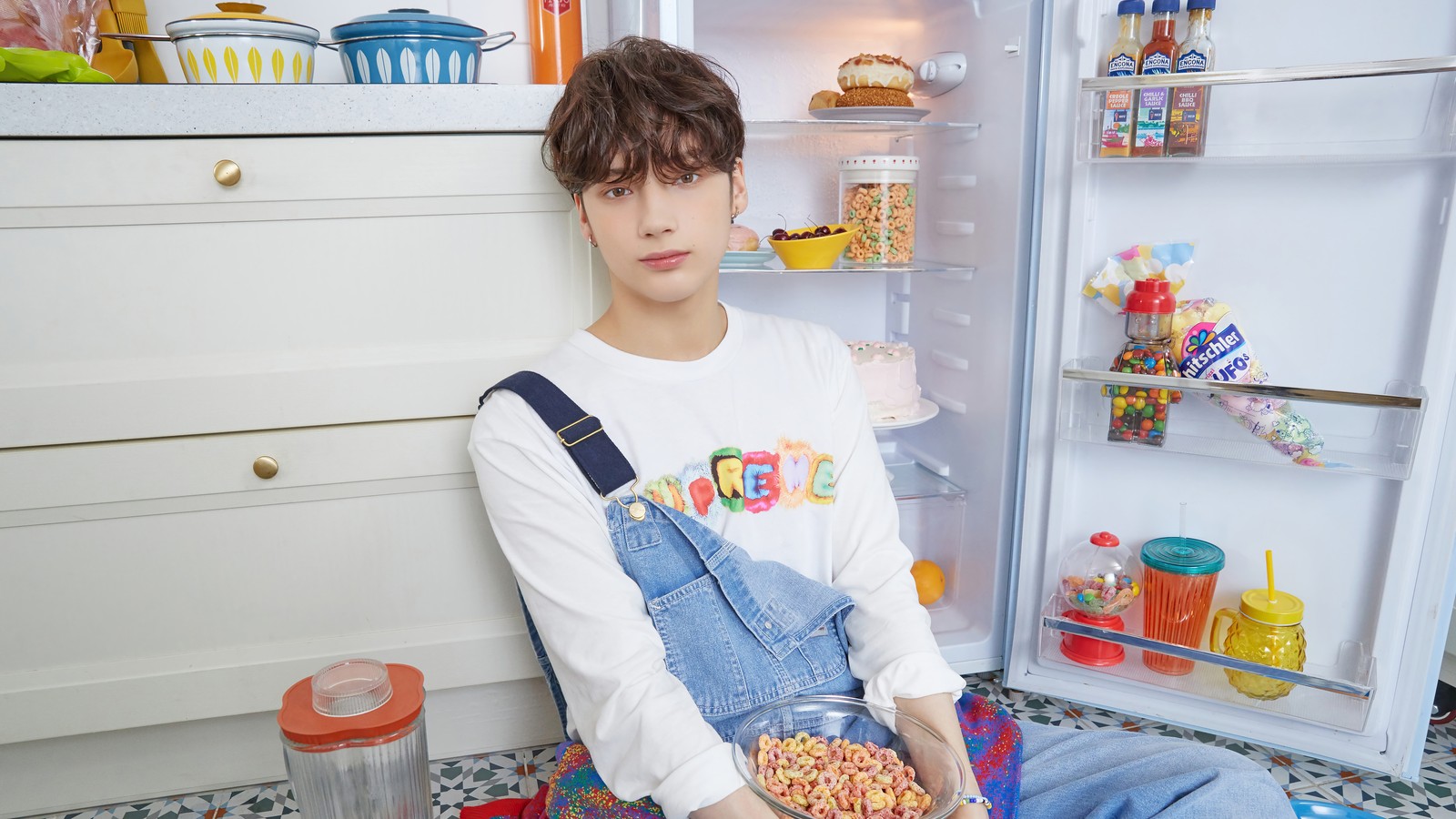 Hay un joven sentado en el suelo frente a un refrigerador (txt kpop, tomorrow x together, 투모로우바이투게더, kpop, k pop)