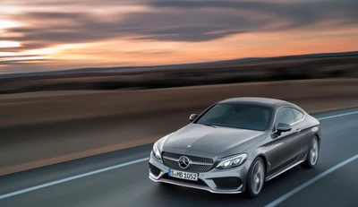 Elegante coupé Mercedes-Benz en una pintoresca carretera abierta