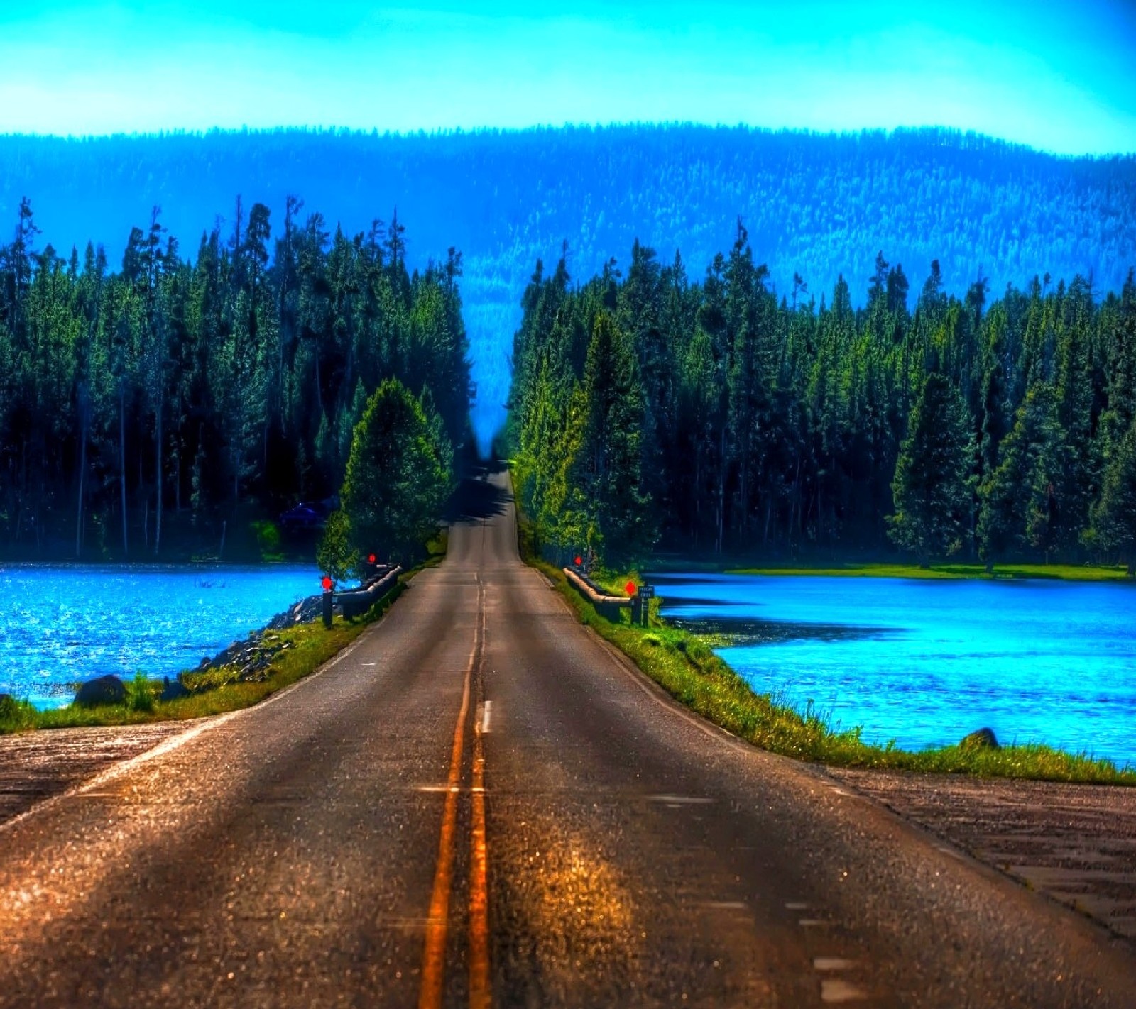 Arafed road with a lake and forest in the background (nature)