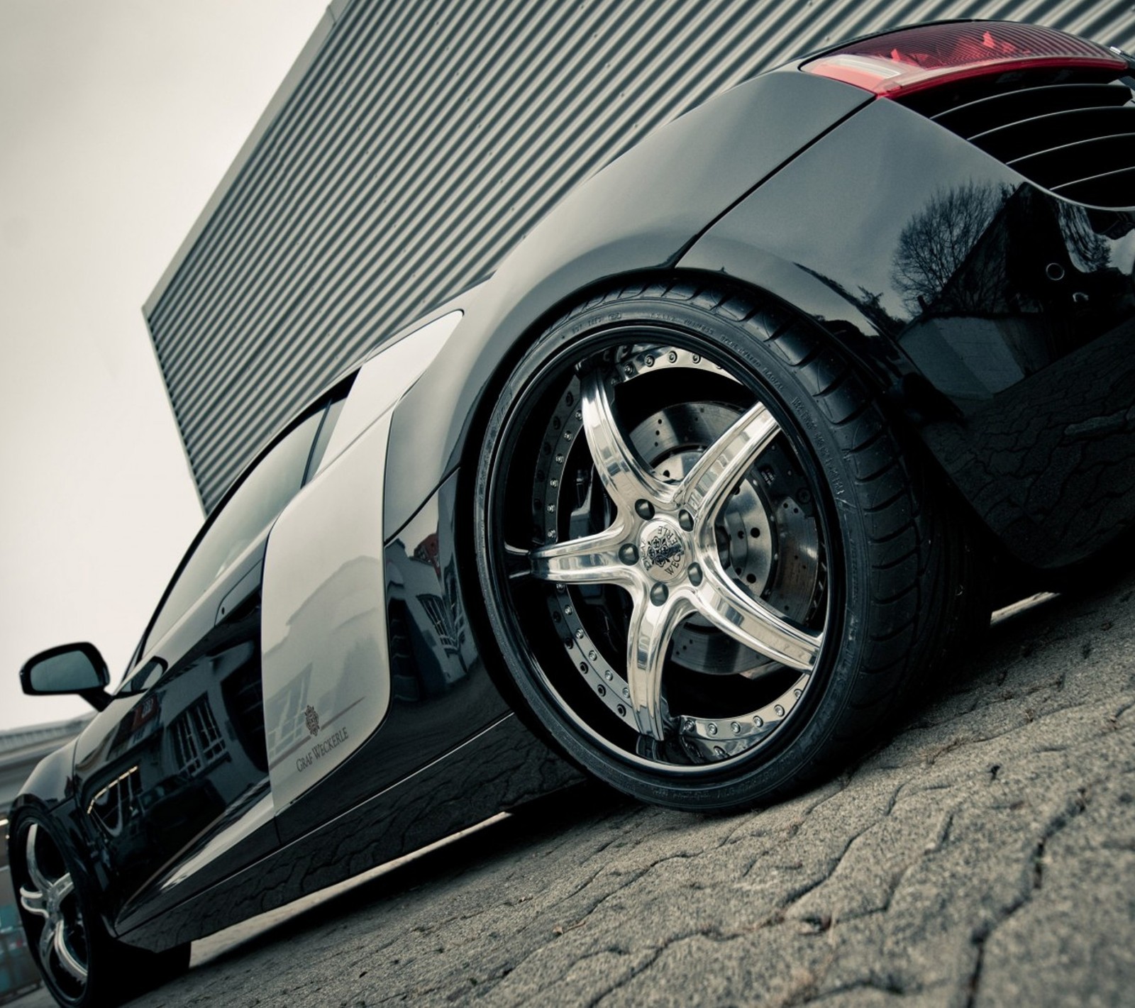 A close up of a car parked on a street near a building (audi r8, best, car, tuned)