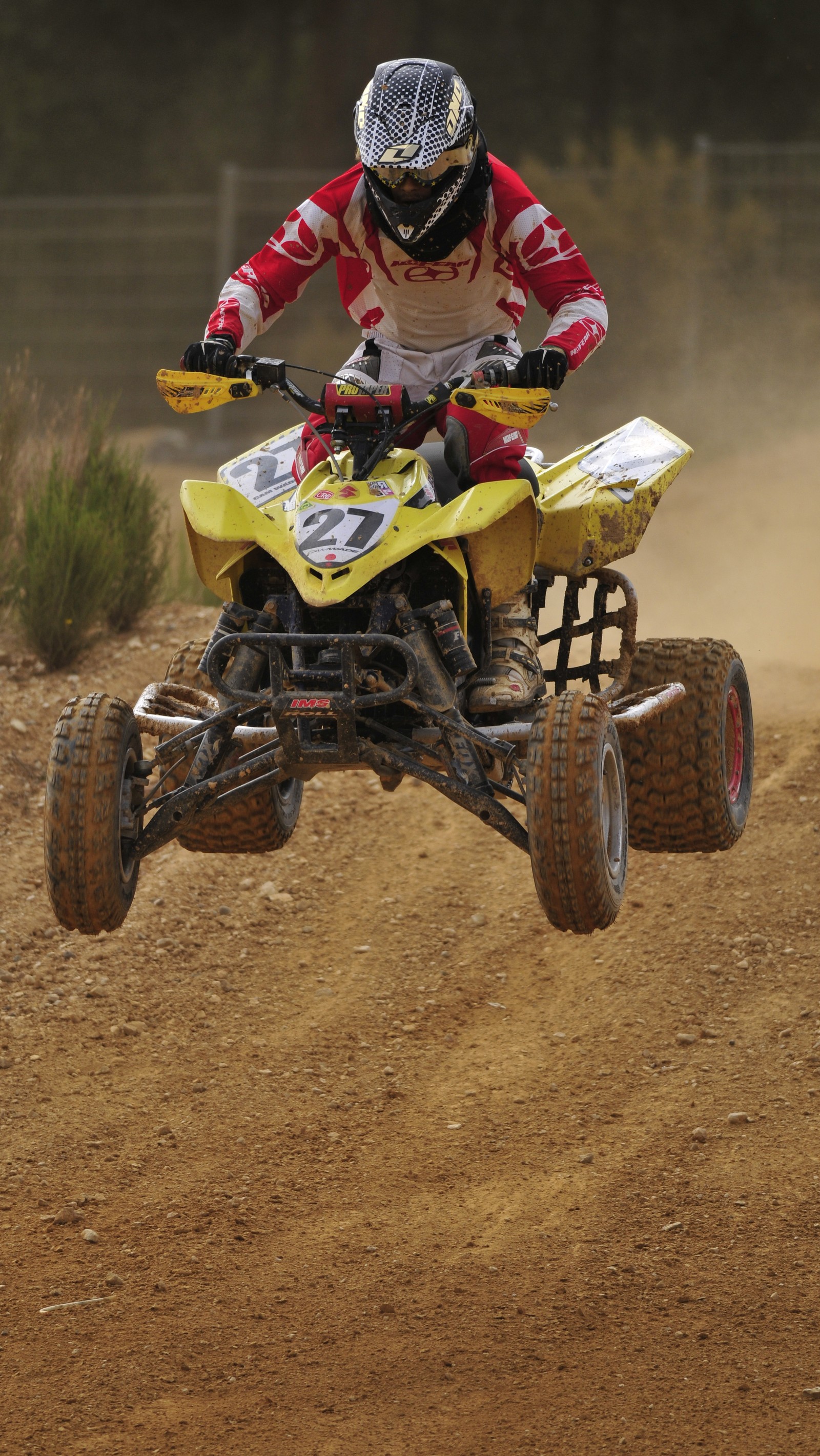 Ein arabischer mann, der auf einem gelben atv auf einer schotterstraße fährt (bikejump, quad)