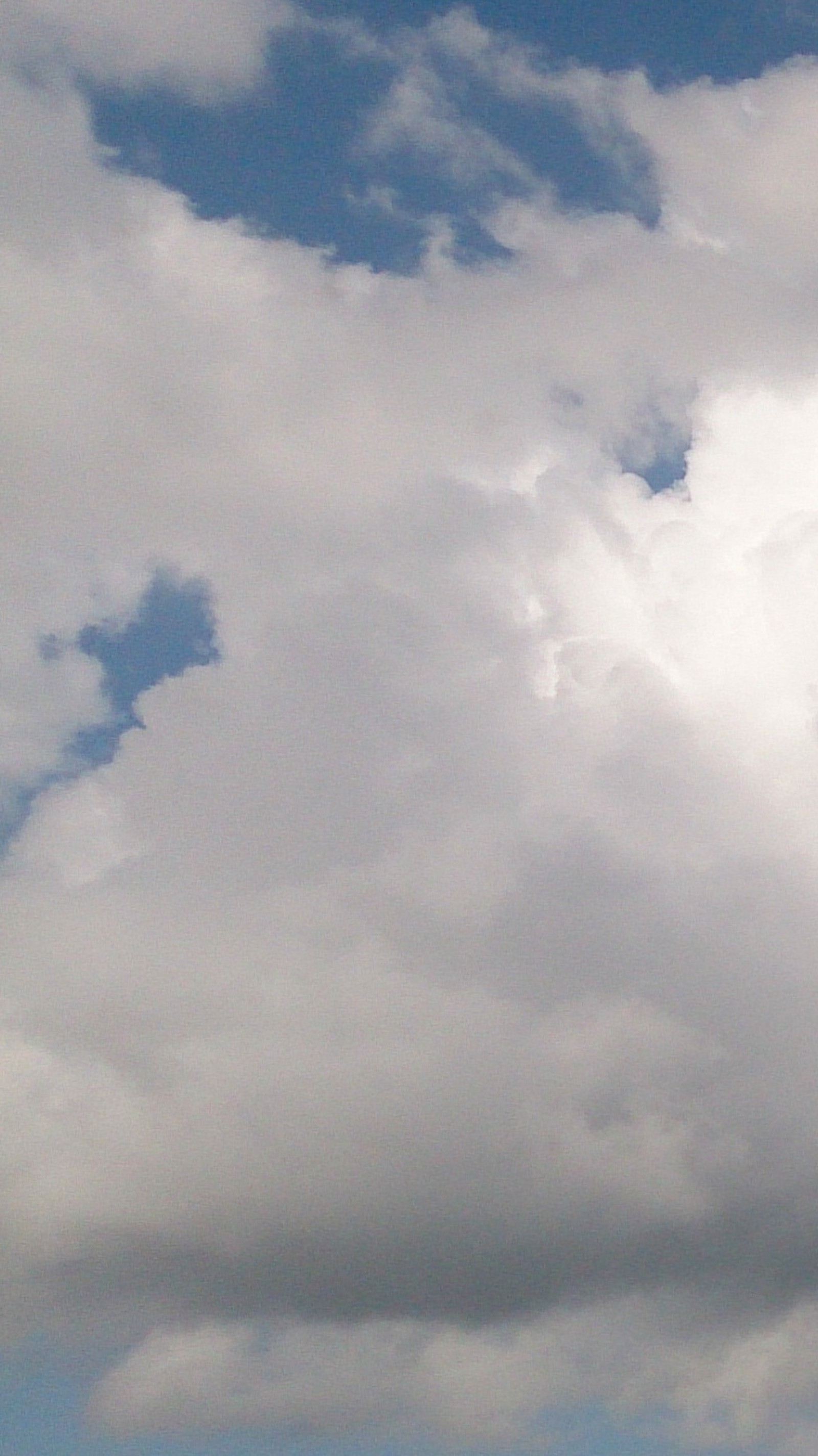 Un avion vole dans le ciel avec un fond nuageux (bleu, nuages, ciel, blanc)