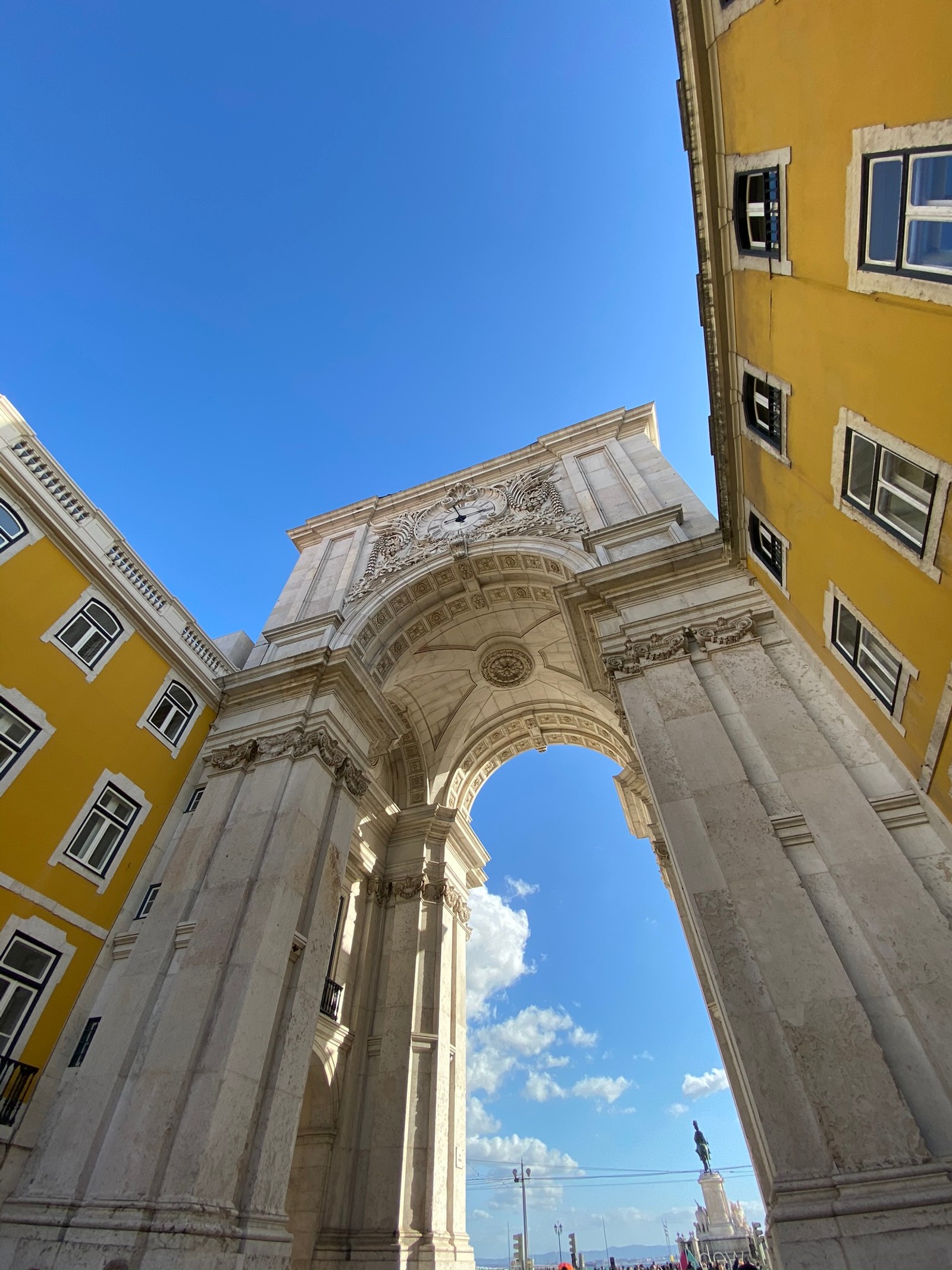 Un arco árabe en una ciudad con un reloj en él (hito, arquitectura clásica, día, arquitectura, fachada)