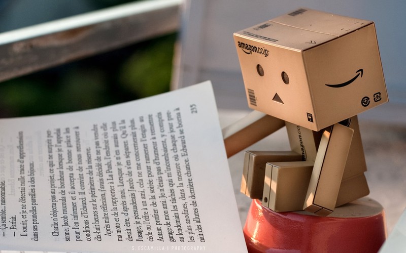 На книге сидит картонный робот. (данбо, danbo, шрифт, робот, amazoncom)