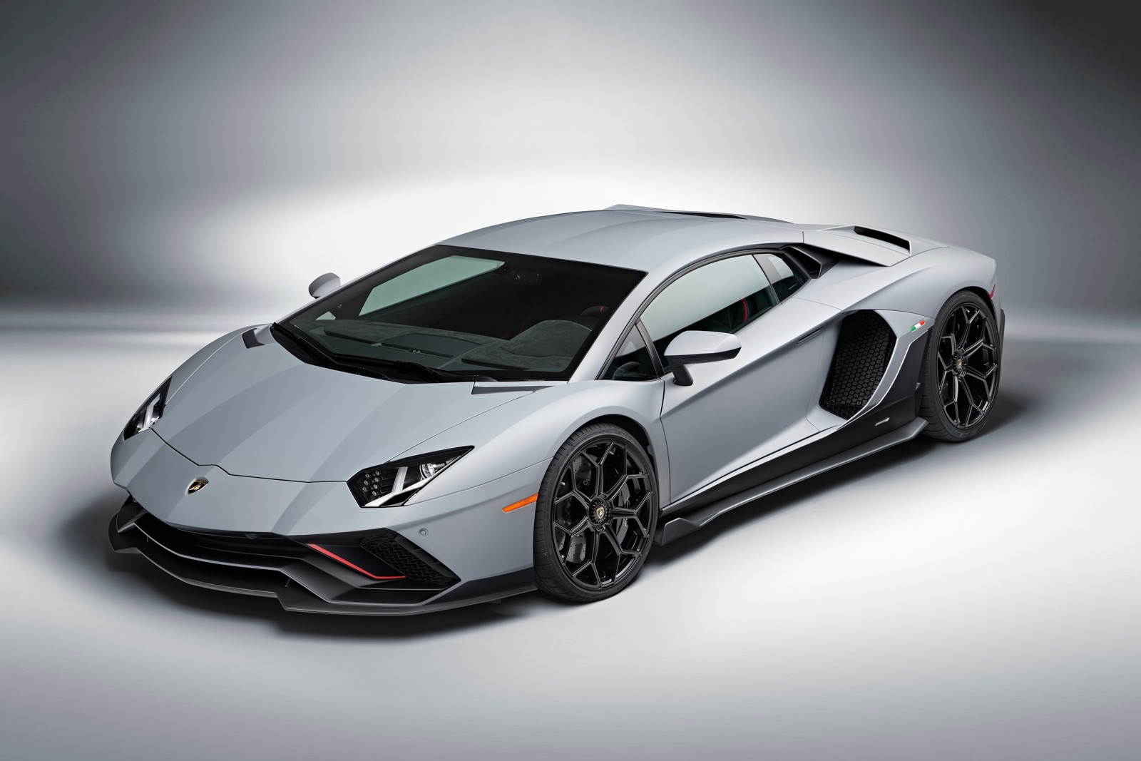 Ein silberner lamborghini-sportwagen, der in einem studio mit hellem hintergrund parkt (lamborghini aventador lp 780 4 ultimae, weiß, supersportwagen, 5k, 8k)