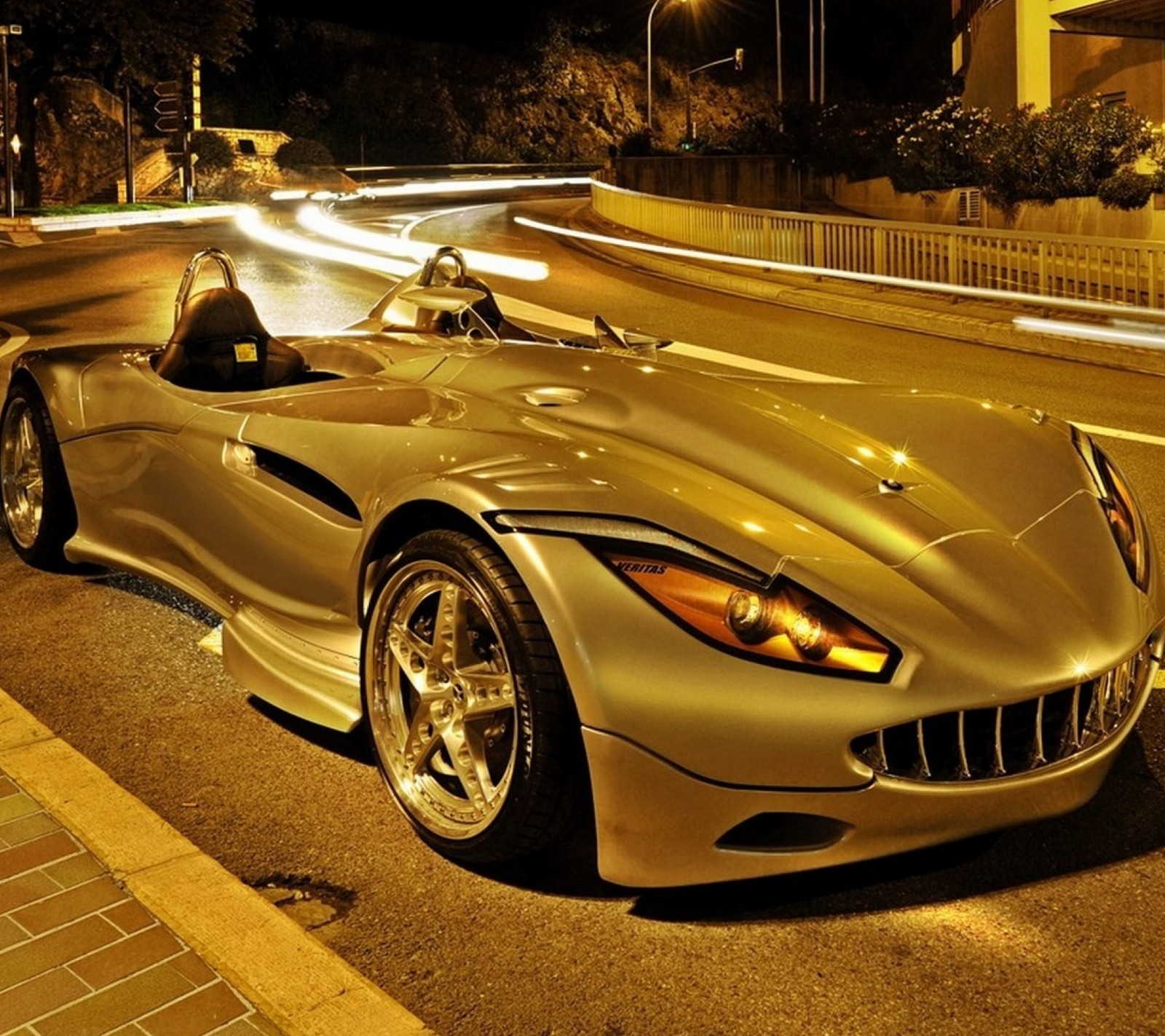 A close up of a silver sports car parked on a street (auto, car, vehicles)