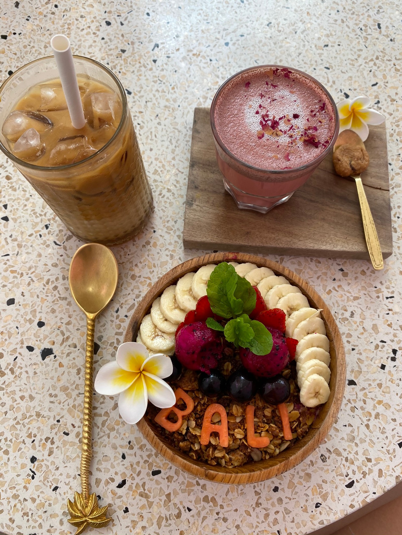 There is a bowl of fruit and a drink on a table (indonesia, bali, superfood, smoothie, breakfast)