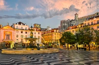 Evening Glow of Lisbon's Historic Town Square with Fountain and Vibrant Architecture