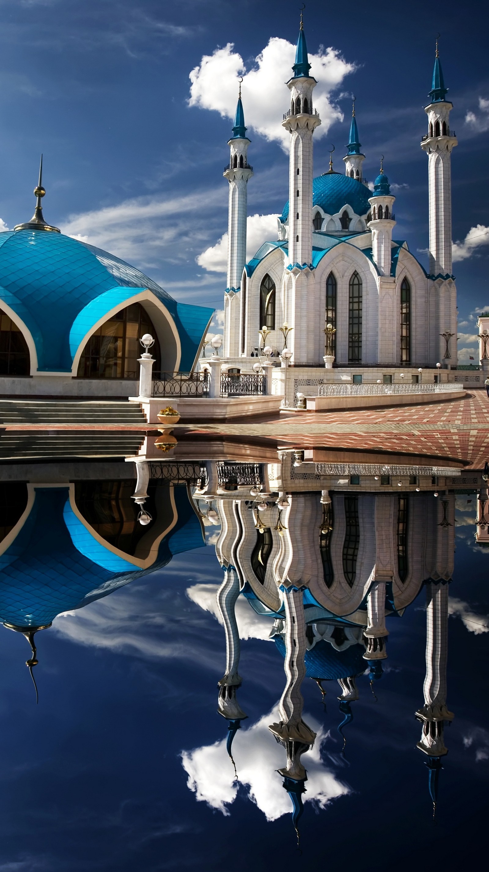 Una vista aérea de una mezquita con un reflejo en el agua (agua, día, nube, mundo, azul)