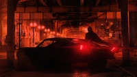 The Batman: Shadowy Vigilante and Iconic Batmobile Under Neon Lights