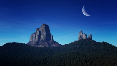 Luna creciente sobre picos montañosos majestuosos por la noche