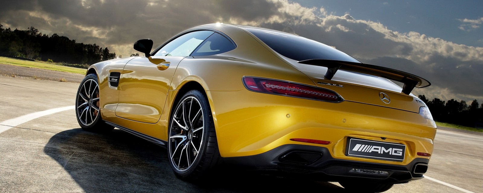 A yellow mercedes sports car driving on a road under a cloudy sky (supercar, sports car, car, mercedes benz slr mclaren, family car)