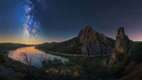 Noche estrellada sobre paisaje de río montañoso