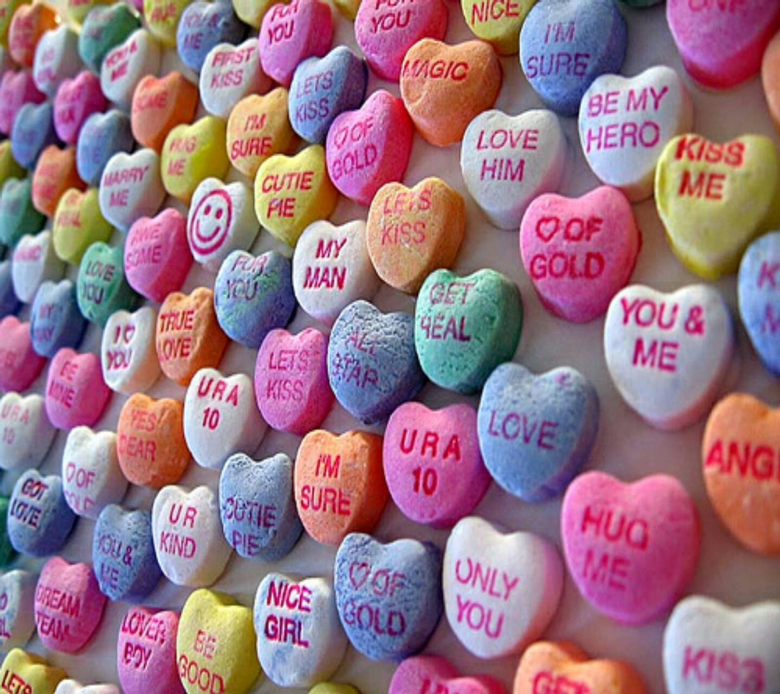 Un gros plan d'un mur de cœurs en bonbon avec des mots écrits dessus (joyeuse saint valentin, cœurs, amour)