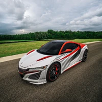 Striking white and red supercar on a racetrack surrounded by lush greenery.