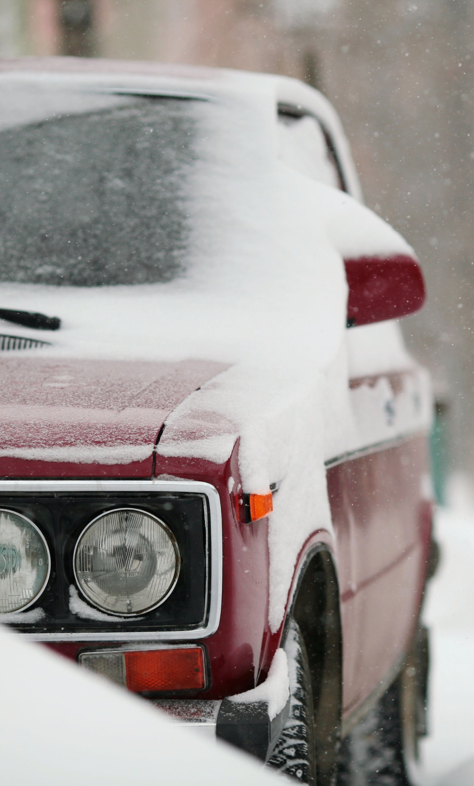 Um carro vermelho estacionado na neve na rua (urss, cccp, vaz)