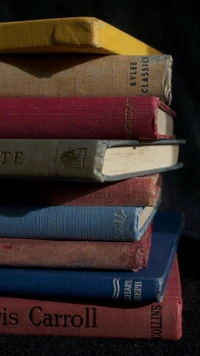 Stack of vintage books in various colors, symbolizing knowledge and study.