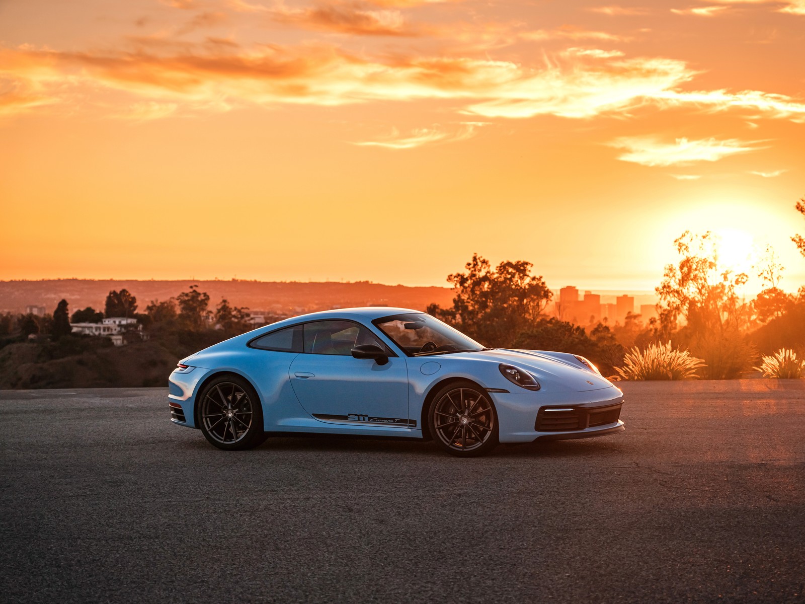 Ein blauer porsche 911, der vor einem sonnenuntergang parkt (porsche 911 carrera t, sonnenuntergang, 2022, 5k, 8k)