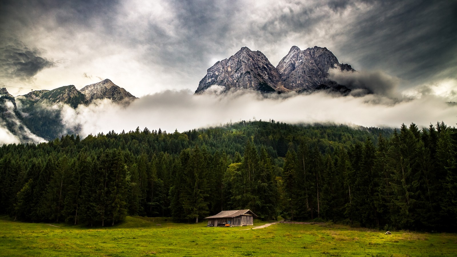 Uma pequena cabana em um campo com montanhas ao fundo (montanha, natureza, formas montanhosas, cadeia de montanhas, wild)