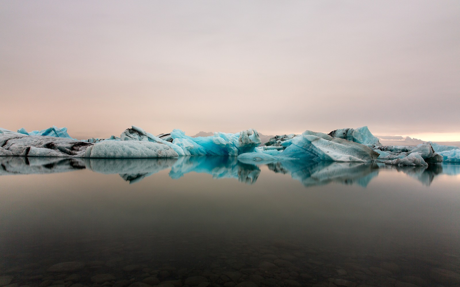 Icebergs flotando en un lago con un cielo nublado (agua, iceberg, glaciar, hielo, casquete polar)