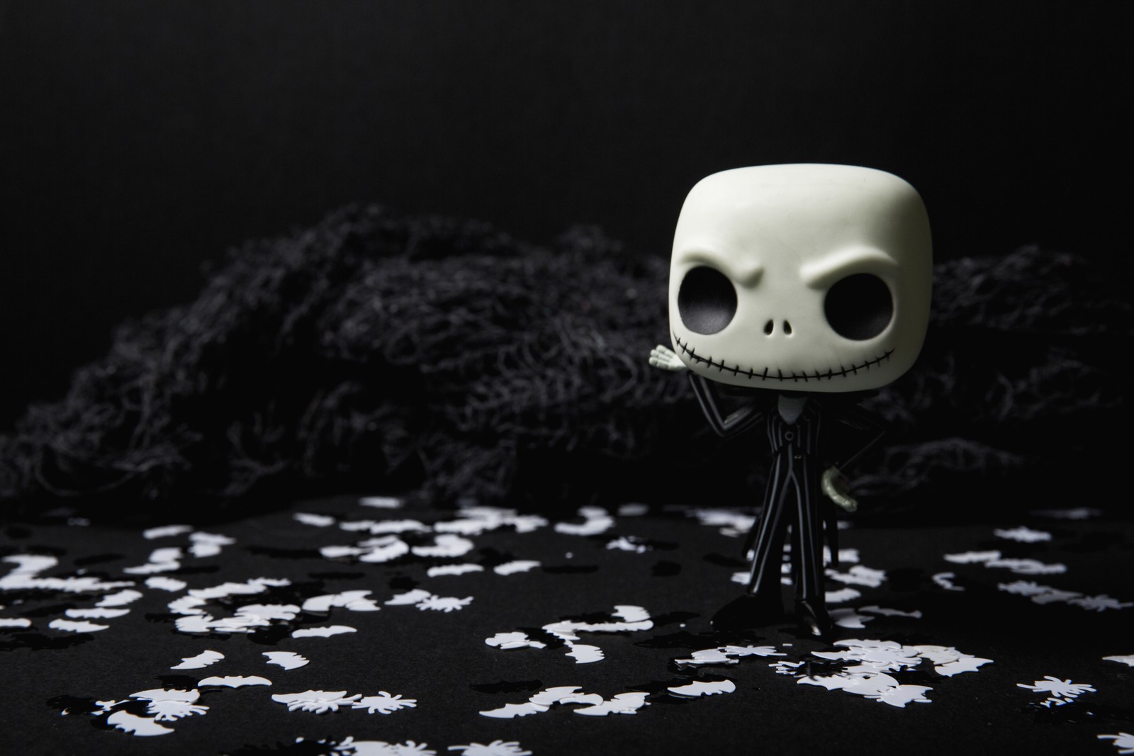 There is a small white skull figurine on a black background (animation, skull, water, darkness, monochrome)