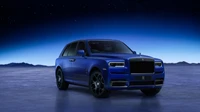 Rolls Royce Cullinan Black Badge en bleu frappant contre un ciel étoilé