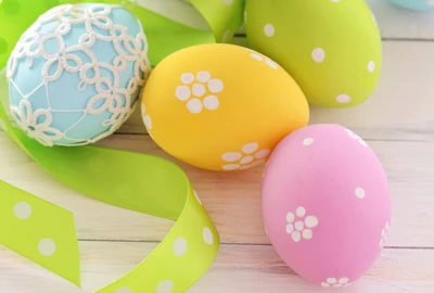 Huevos de Pascua coloridos adornados con patrones florales y cintas.