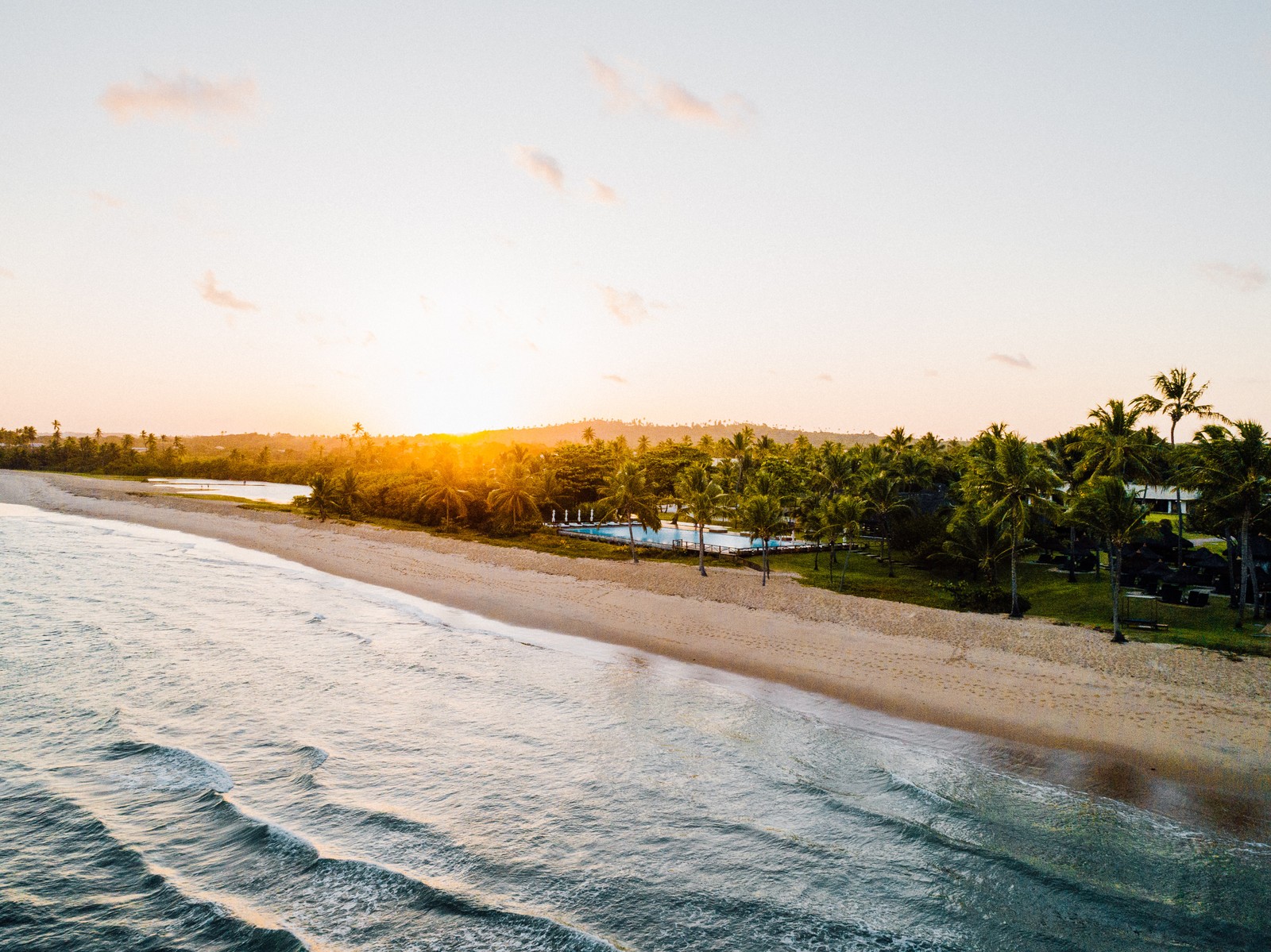 Vue d'une plage avec un plan d'eau et des palmiers (eau, nuage, ressources en eau, plante, paysage naturel)