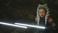 Ahsoka Tano empuñando dos sables de luz en una postura dramática, personificando la fuerza y la determinación.