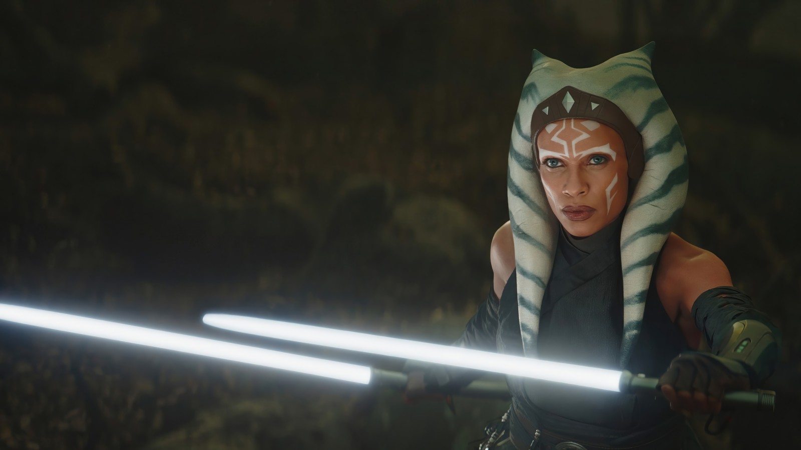 Una mujer en un disfraz con una espada en una cueva (ahsoka tano, dual, sable de luz, lightsaber, serie ahsoka)