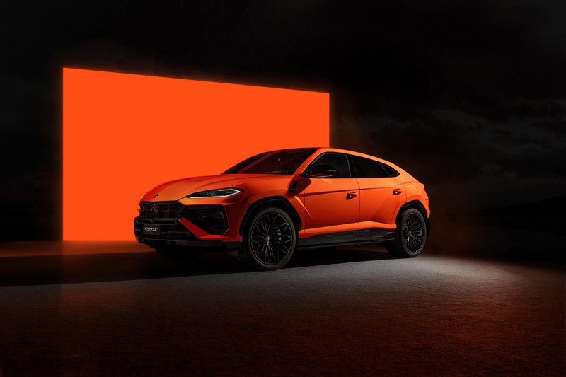 Близкий план ламбы suv на фоне ярко-оранжевого экрана (lamborghini urus se, гибридный внедорожник, 5k, 2024, машины)