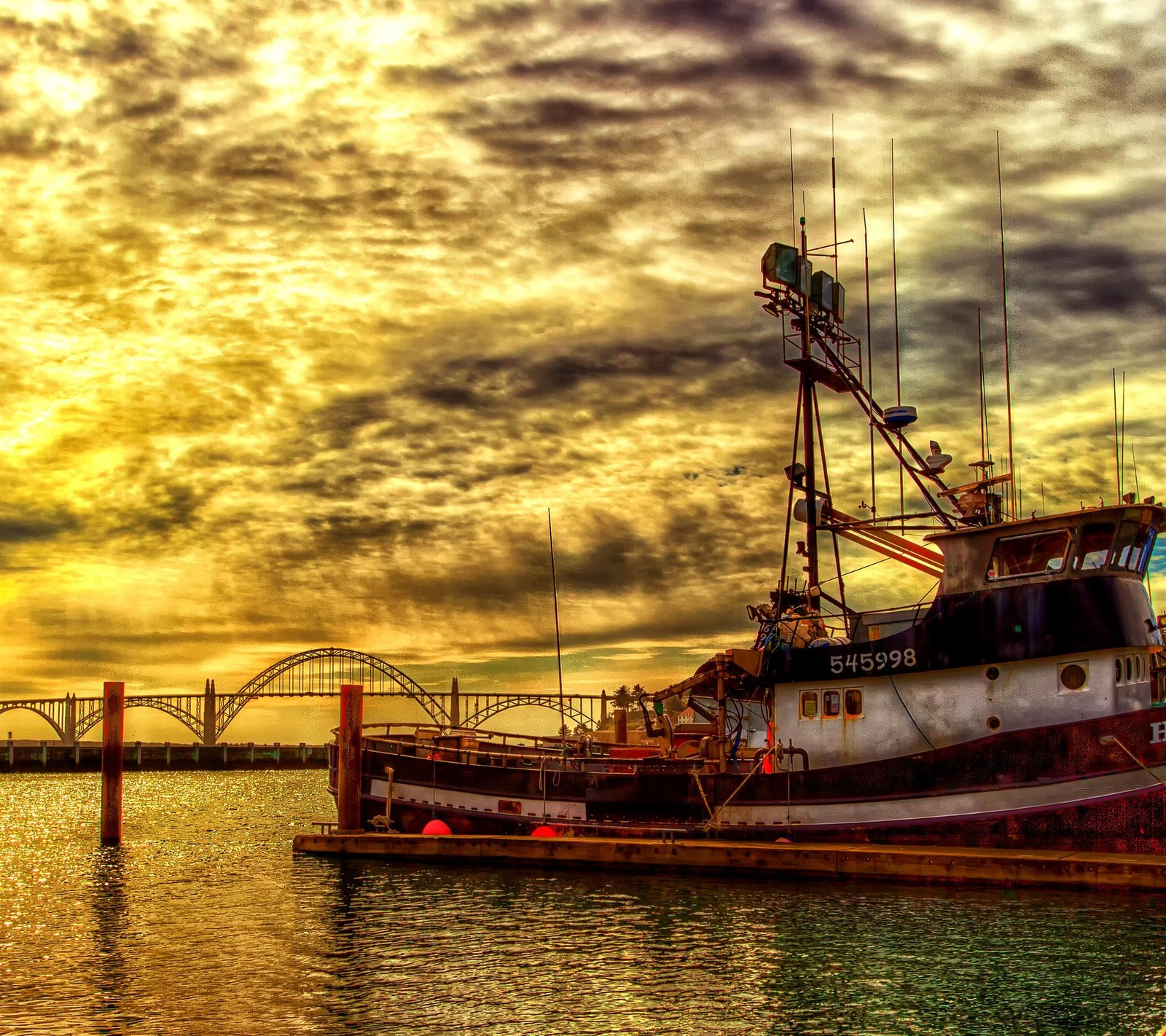 Arafed boat docked at a dock with a bridge in the background (clouds, hd, nature, sea, ship)