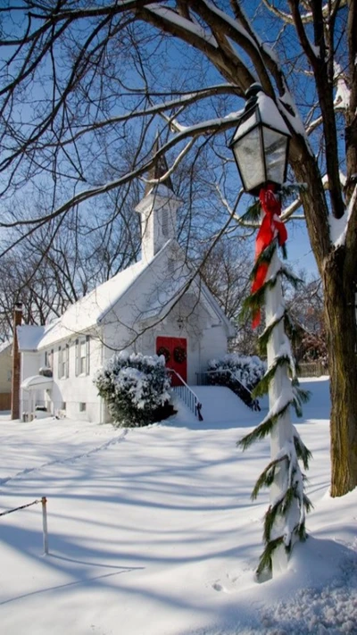 Snow-covered landscape featuring a charming white church adorned with a red door and holiday decorations, surrounded by serene winter scenery.