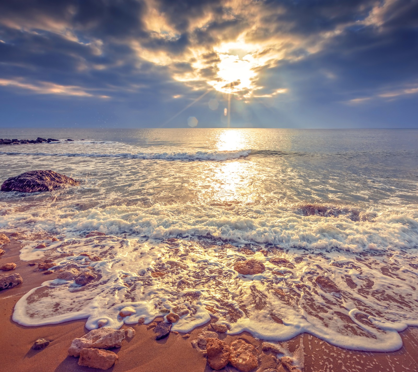 A close up of a beach with waves and rocks on the shore (nature, ocean, sun, sunset, water)