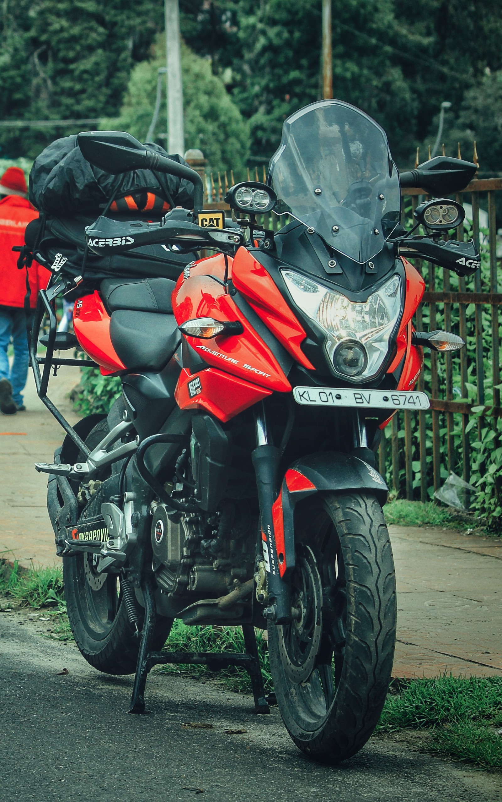 Hay una motocicleta roja estacionada al lado de la carretera (bicicletas, motor, motocicleta, acrobacia)