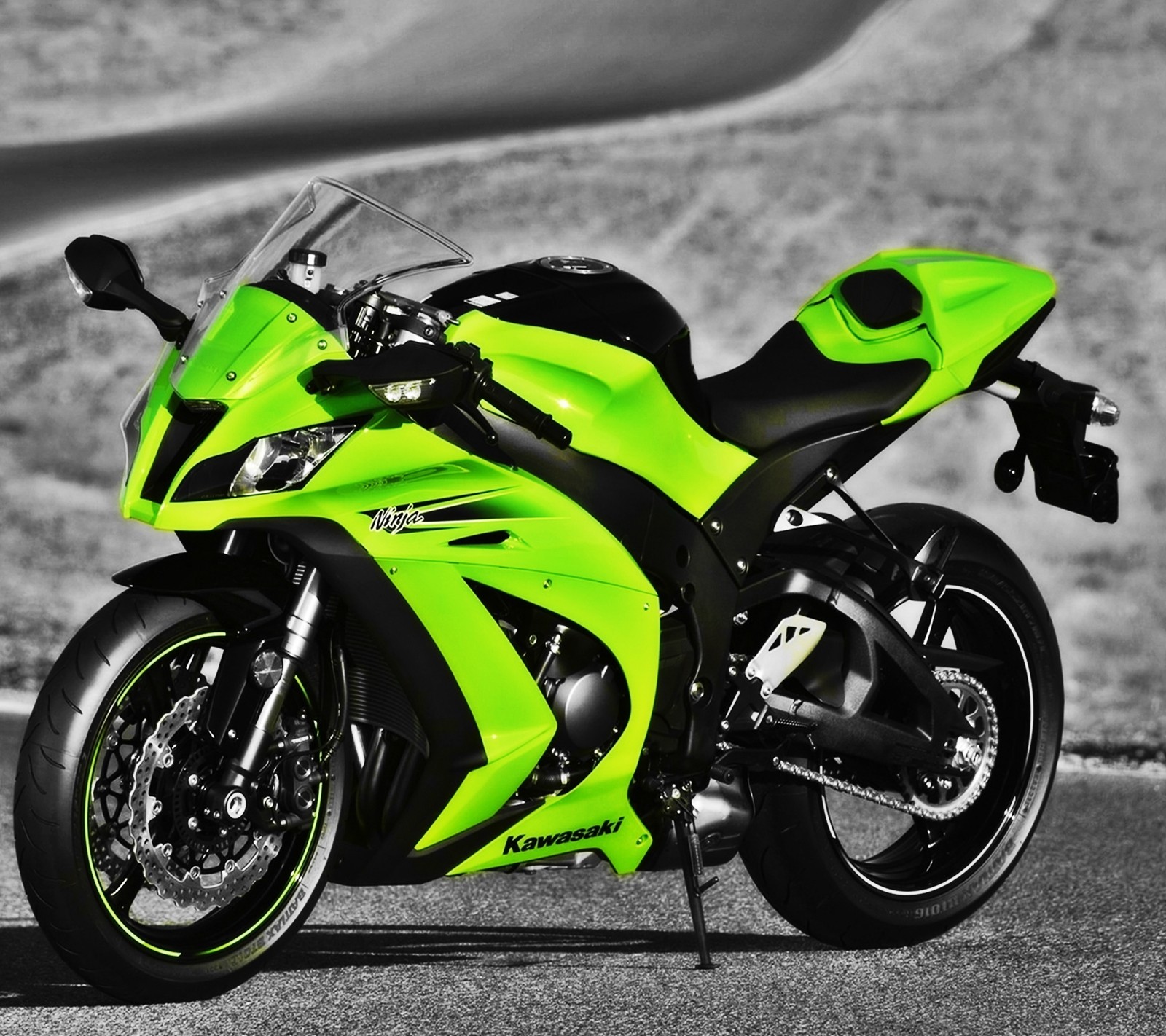 A close up of a neon green motorcycle parked on a road (bike, green, kawasaki, ninja)