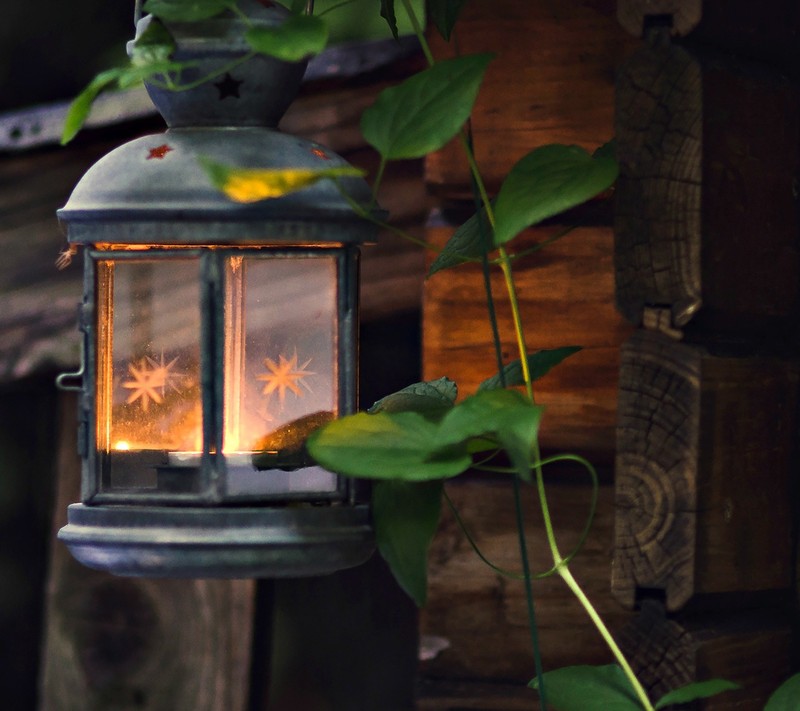 There is a small lantern that is lit up on a porch (hd, lantern)