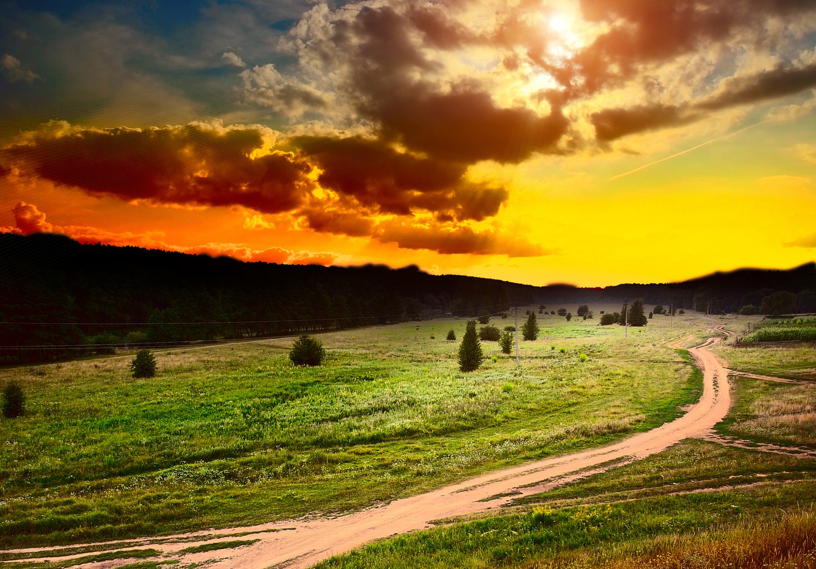 Vista de uma estrada de terra passando por um campo com um pôr do sol ao fundo (natureza, nuvem, grama, luz solar, manhã)