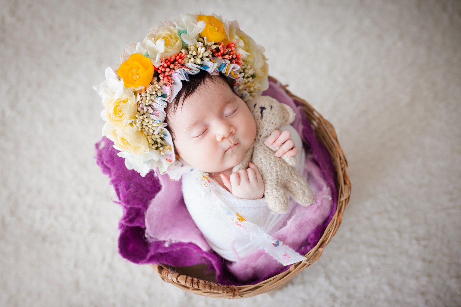 Arabisches baby in einem korb mit einem stofftier und blumen (neugeborenes, blumenkranz, sleeping baby, weißer pelz, korb)